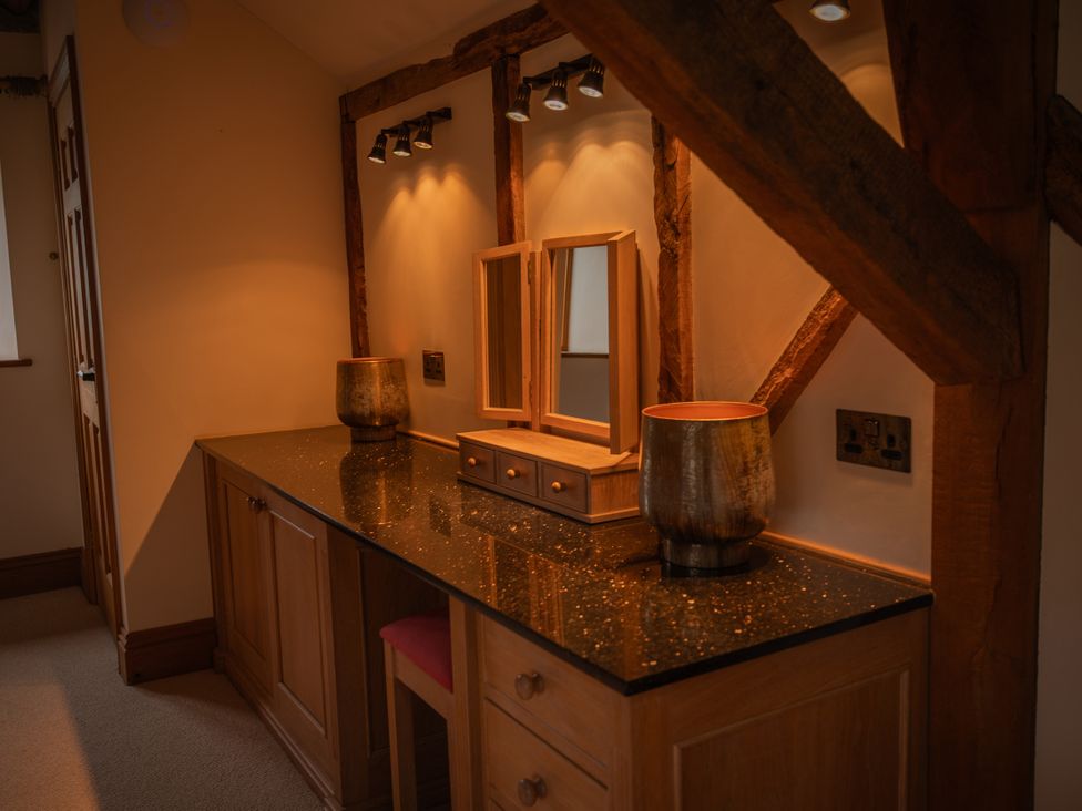 A vanity unit with a mirror and decorative items at Stud Farm House Bleddfa near Knighton
