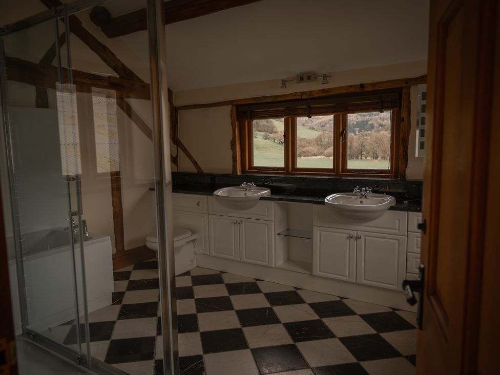 A bathroom with sinks and a bathtub at Stud Farm House Bleddfa near Knighton