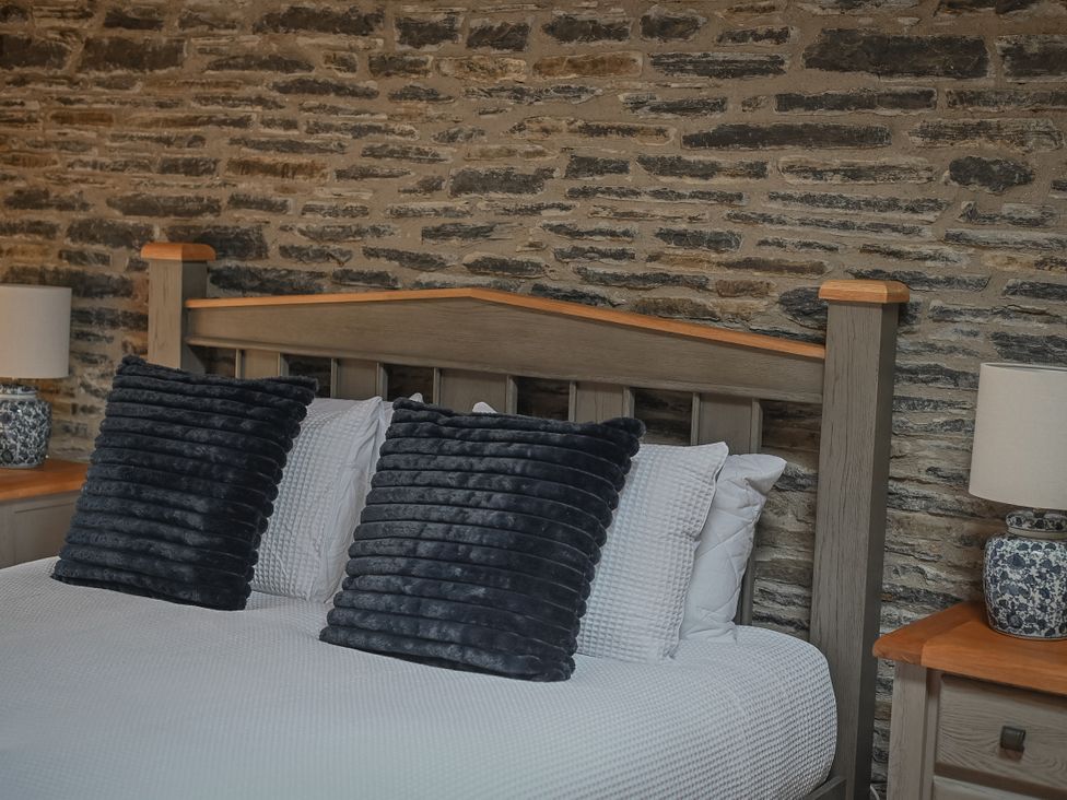 A bedroom with a bed and stone wall at Stud Farm House Bleddfa near Knighton