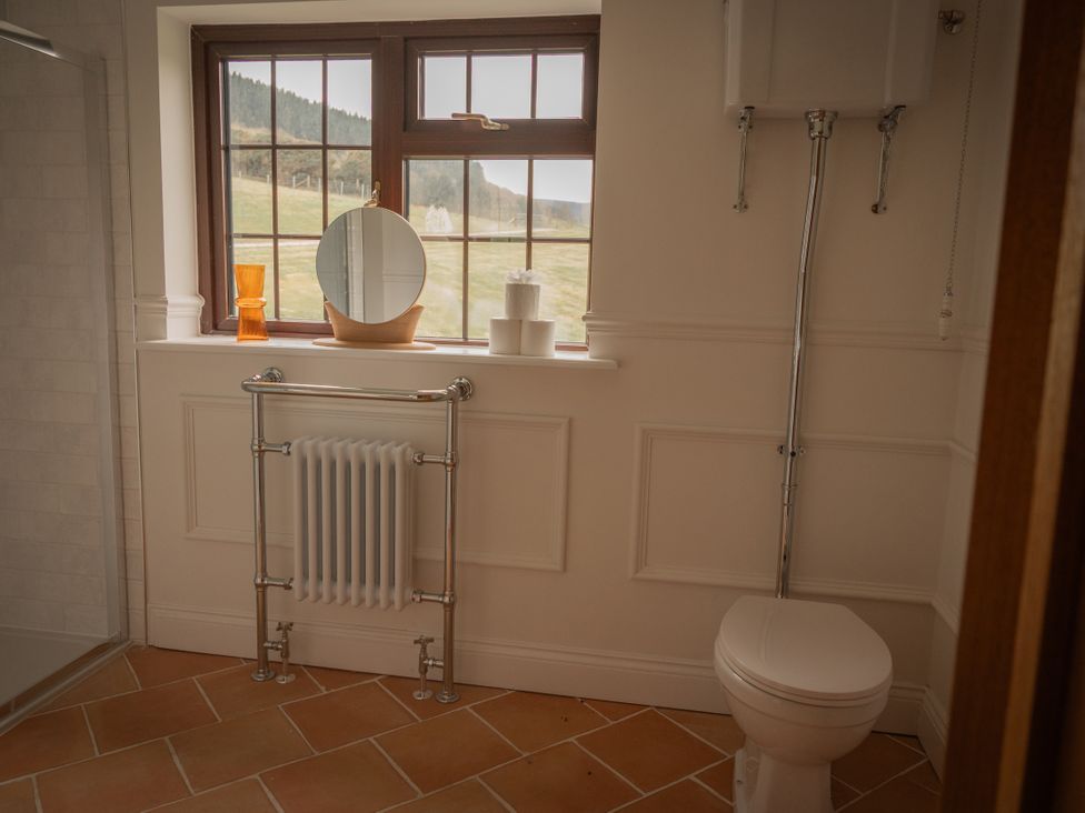 A bathroom with a toilet and mirror at Stud Farm House Bleddfa near Knighton