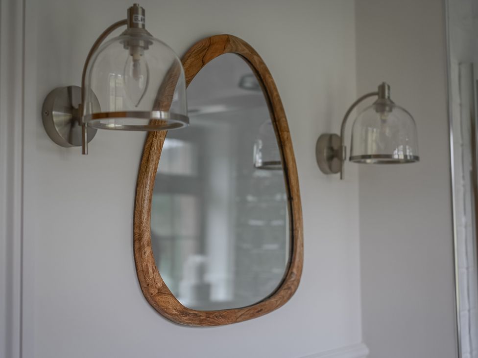A bathroom with a mirror and light fixtures at Stud Farm House in Bleddfa near Knighton