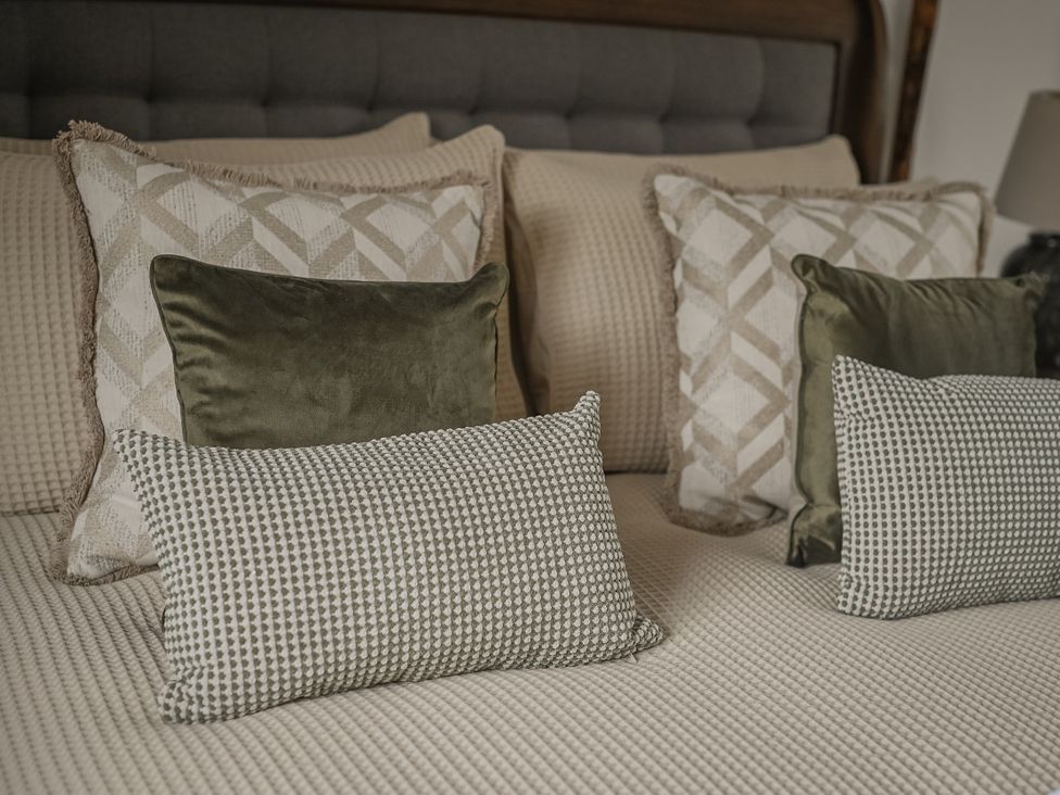 A bed with patterned pillows at Stud Farm House Bleddfa near Knighton