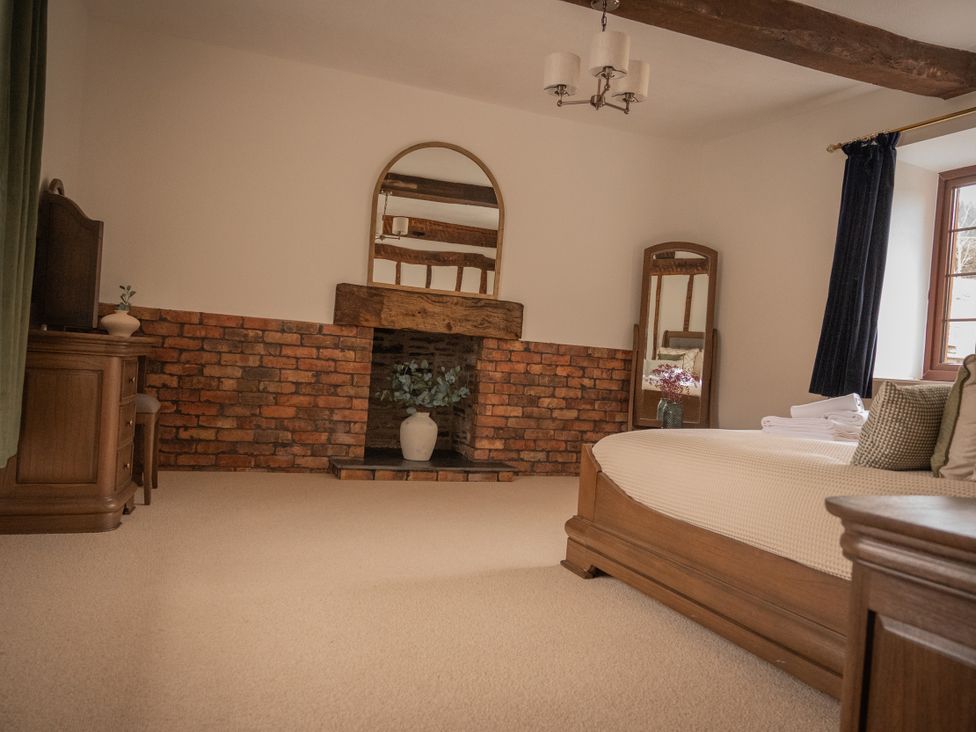 A bedroom with a bed and mirror at Stud Farm House Bleddfa near Knighton