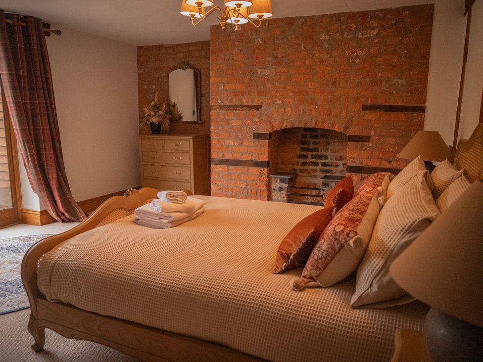 A bedroom with a bed and a fireplace at Stud Farm House Bleddfa near Knighton
