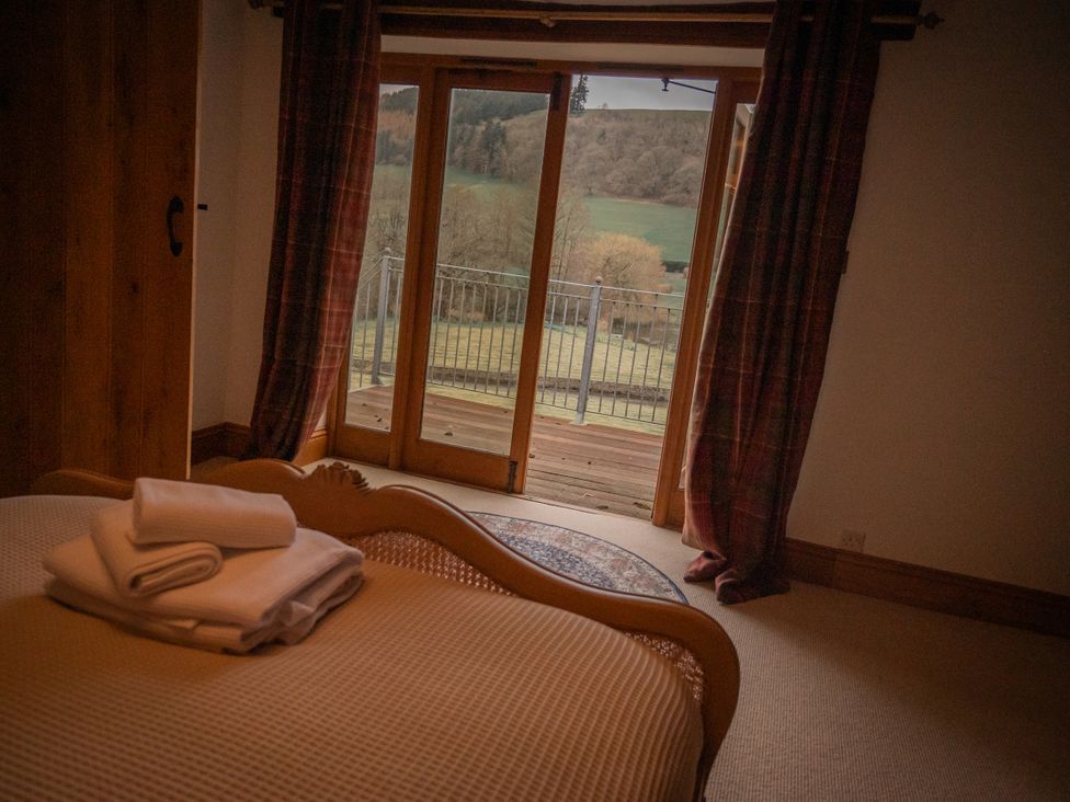A bedroom with a view of a balcony at Stud Farm House in Bleddfa near Knighton