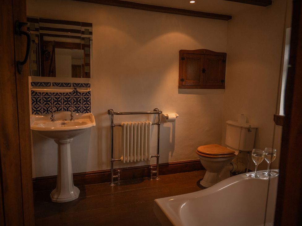A bathroom with a sink, toilet, and bath tub at Stud Farm House Bleddfa near Knighton