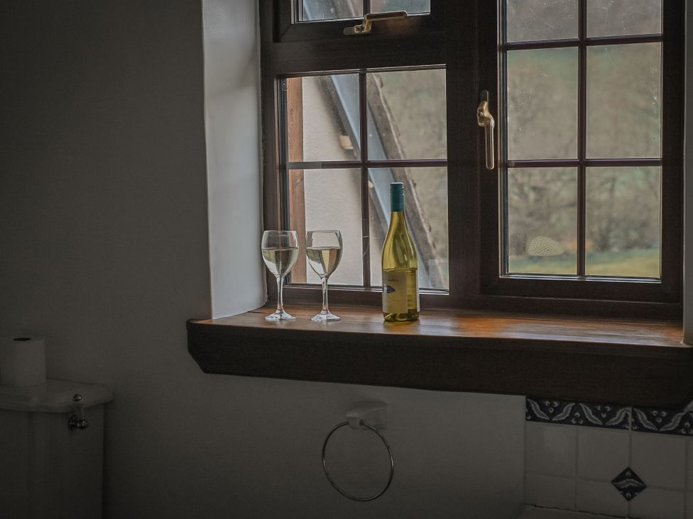 A bathroom window with wine glasses and a wine bottle at Stud Farm House Bleddfa near Knighton
