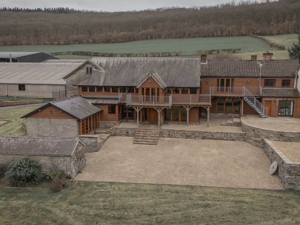 An outdoor view of a house with a garden and balcony at Stud Farm House Bleddfa near Knighton