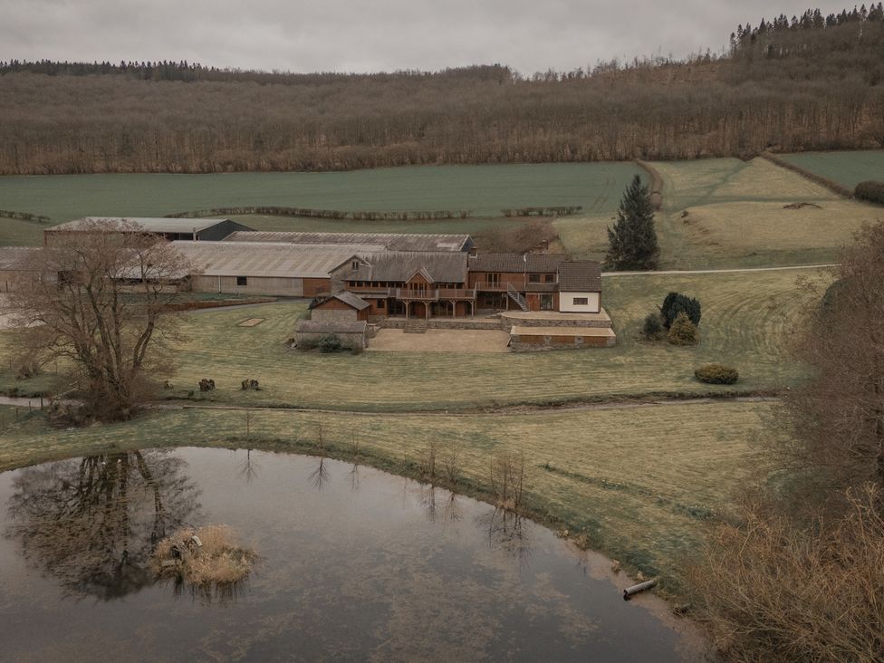 A house and barn with a pond and trees at Stud Farm House Bleddfa near Knighton