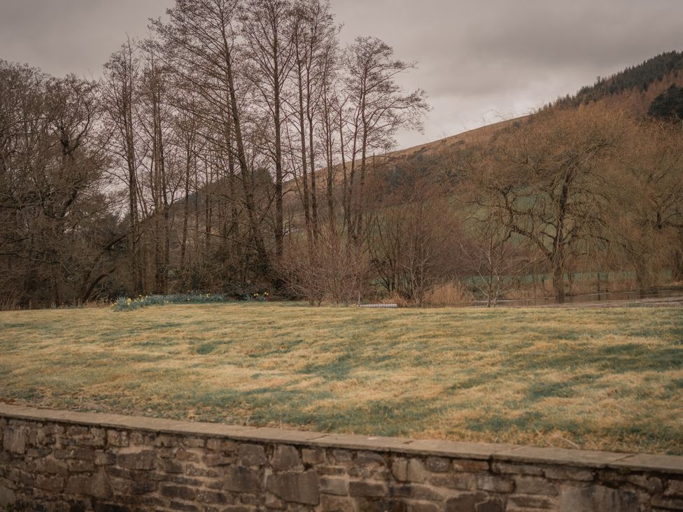 A grassy area with trees and hills at Stud Farm House in Bleddfa near Knighton