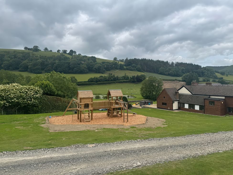A playground with a wooden structure in the garden at Stud Farm House in Bleddfa near Knighton