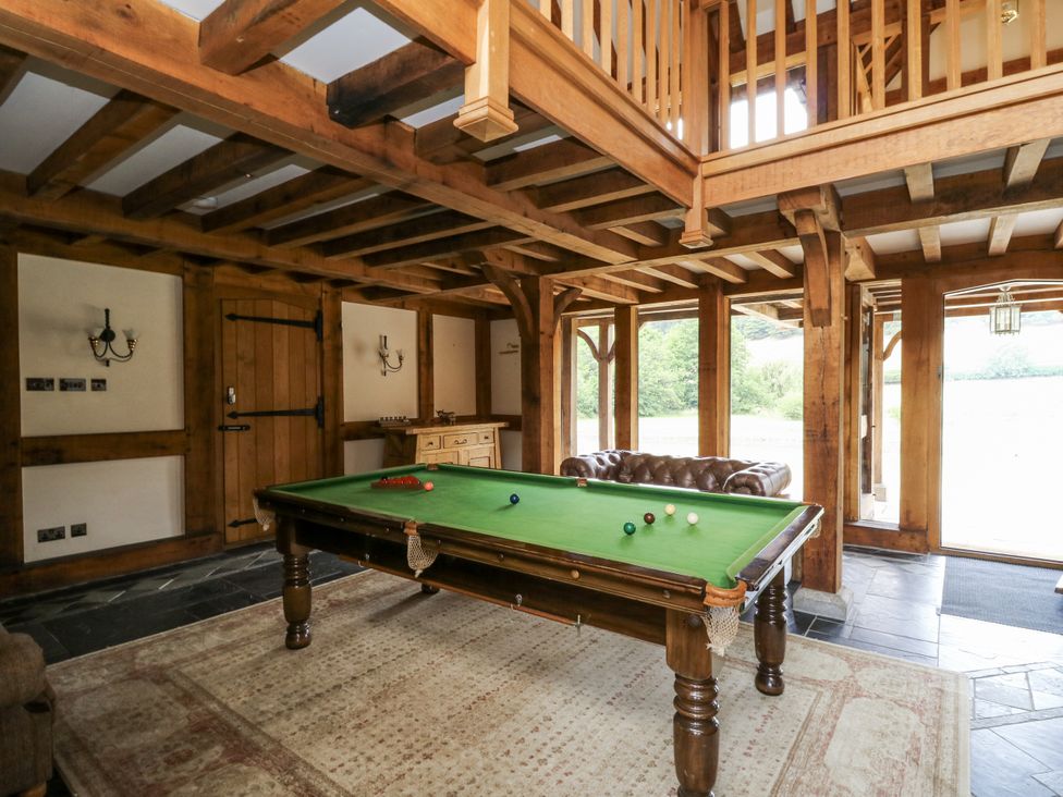 A game room with a pool table and sofa at Stud Farm House in Bleddfa near Knighton