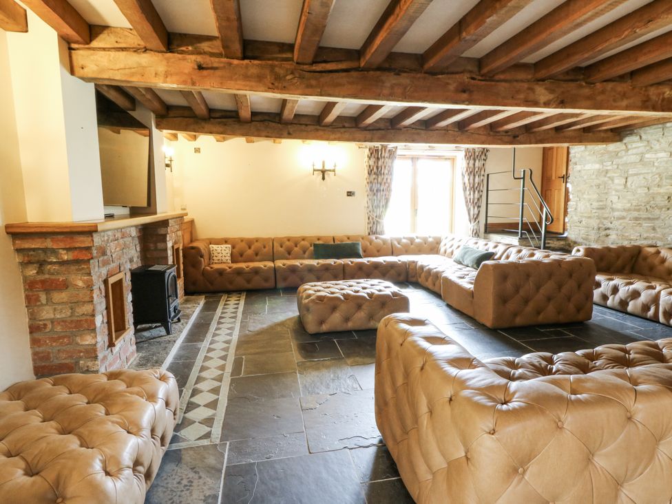 A living room with a brick fireplace and sofa at Stud Farm House in Bleddfa near Knighton