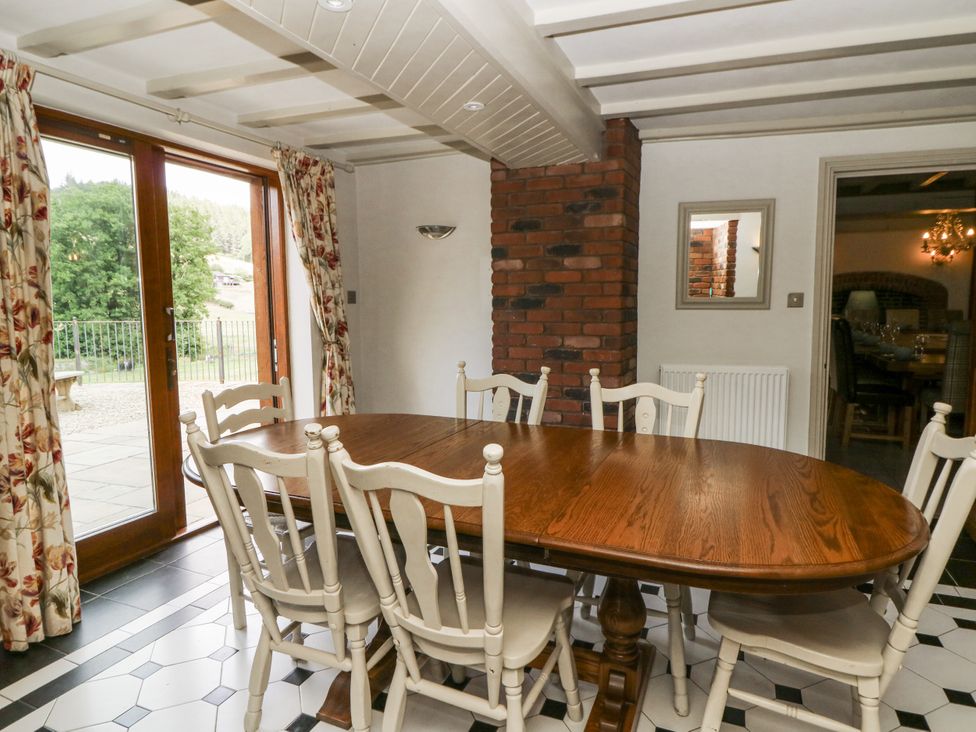 A dining room with a wooden table and chairs at Stud Farm House Bleddfa near Knighton