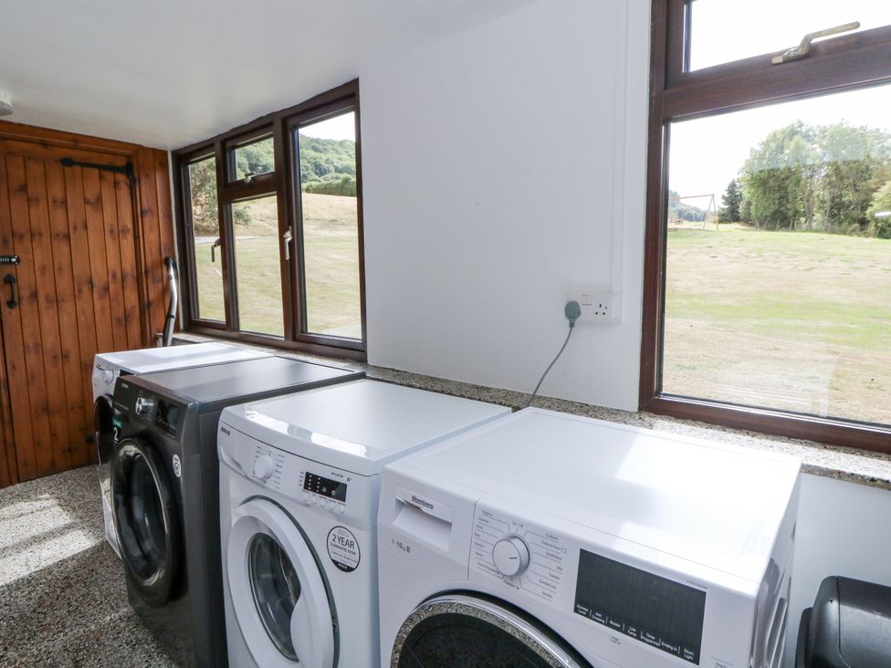 A laundry room with two washing machines and windows at Stud Farm House in Bleddfa near Knighton