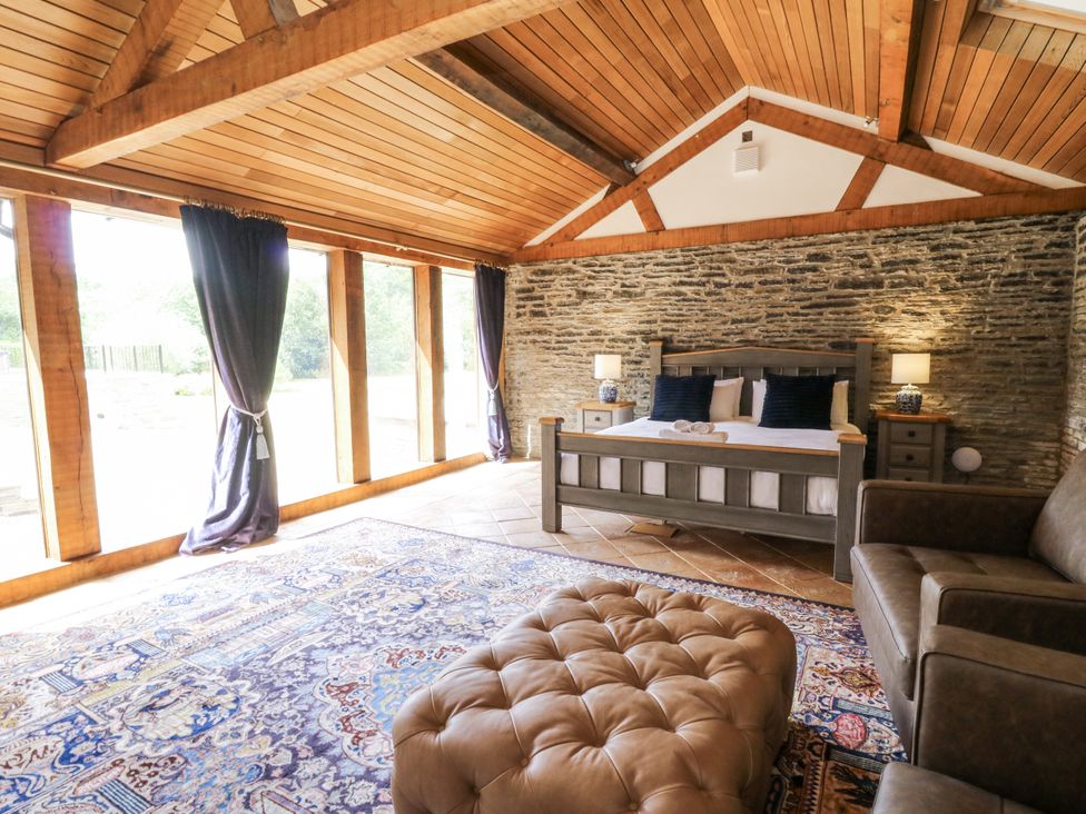 A bedroom with a bed and a sofa at Stud Farm House Bleddfa near Knighton