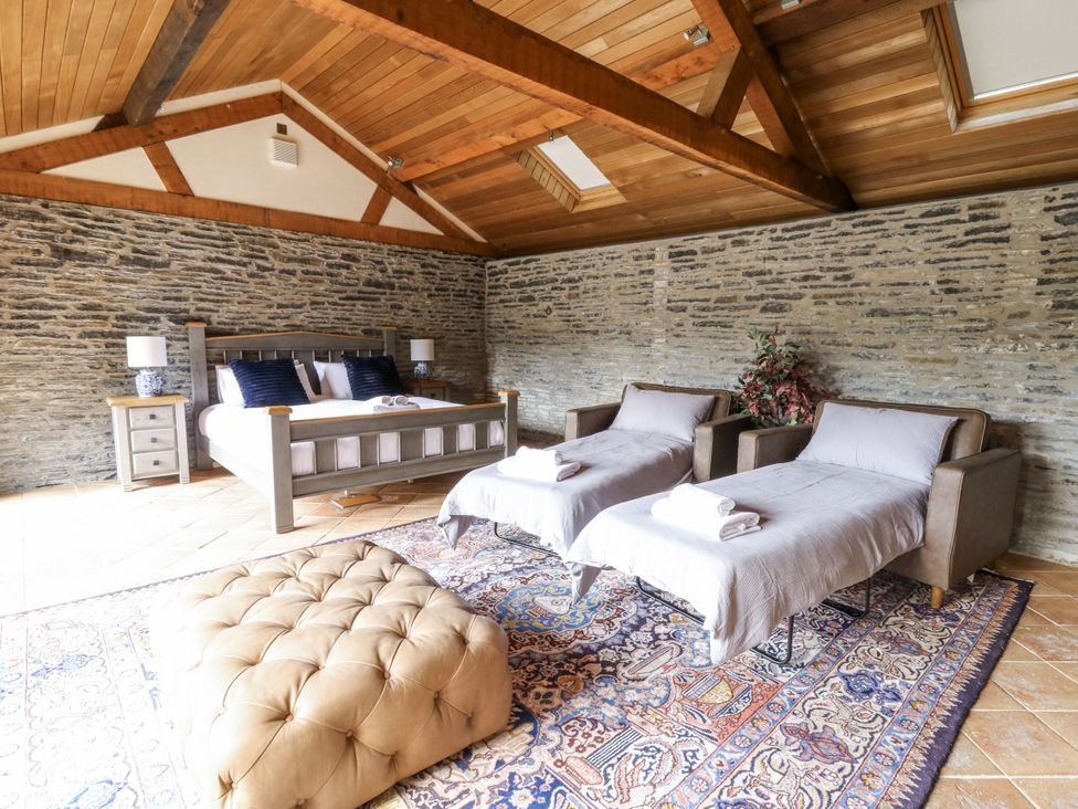 A bedroom with a bed and armchairs at Stud Farm House Bleddfa near Knighton