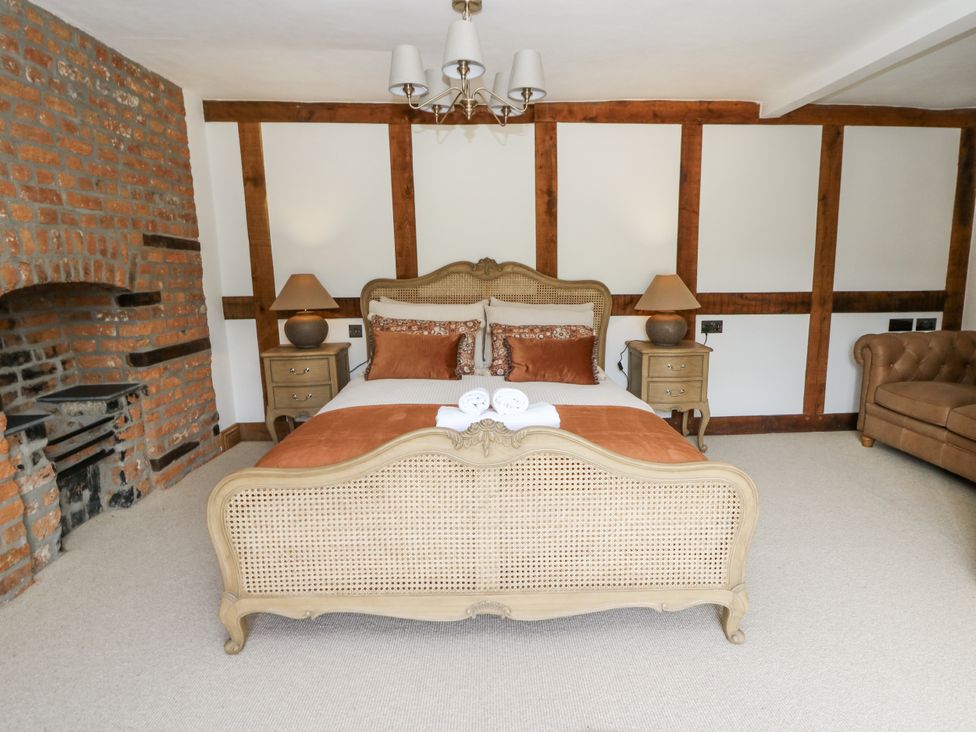 A bedroom with a bed and fireplace at Stud Farm House in Bleddfa near Knighton