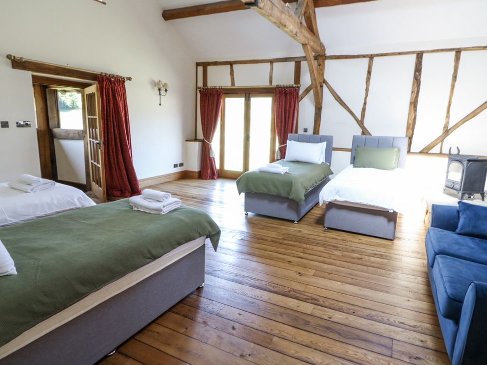 A bedroom with two beds and a sofa at Stud Farm House Bleddfa near Knighton