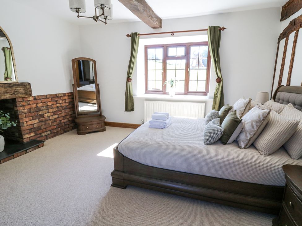 A bedroom with a bed and a mirror at Stud Farm House in Bleddfa near Knighton