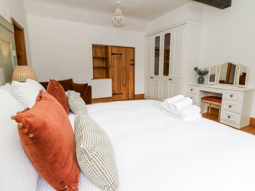 A bedroom with a bed and wardrobe at Stud Farm House in Bleddfa near Knighton