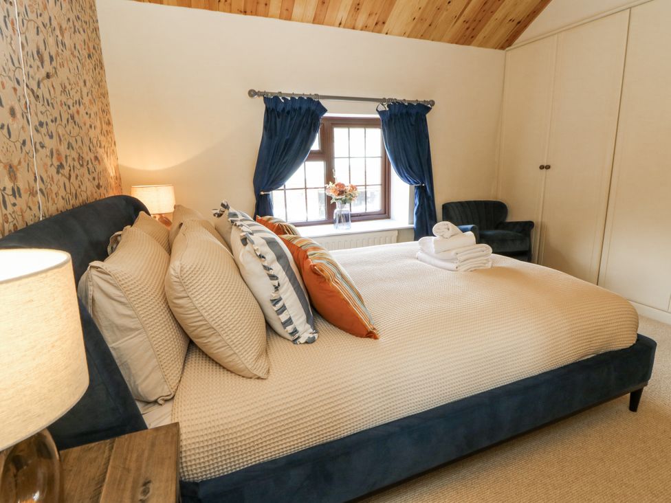 A bedroom with a bed and decorative pillows at Stud Farm House in Bleddfa near Knighton
