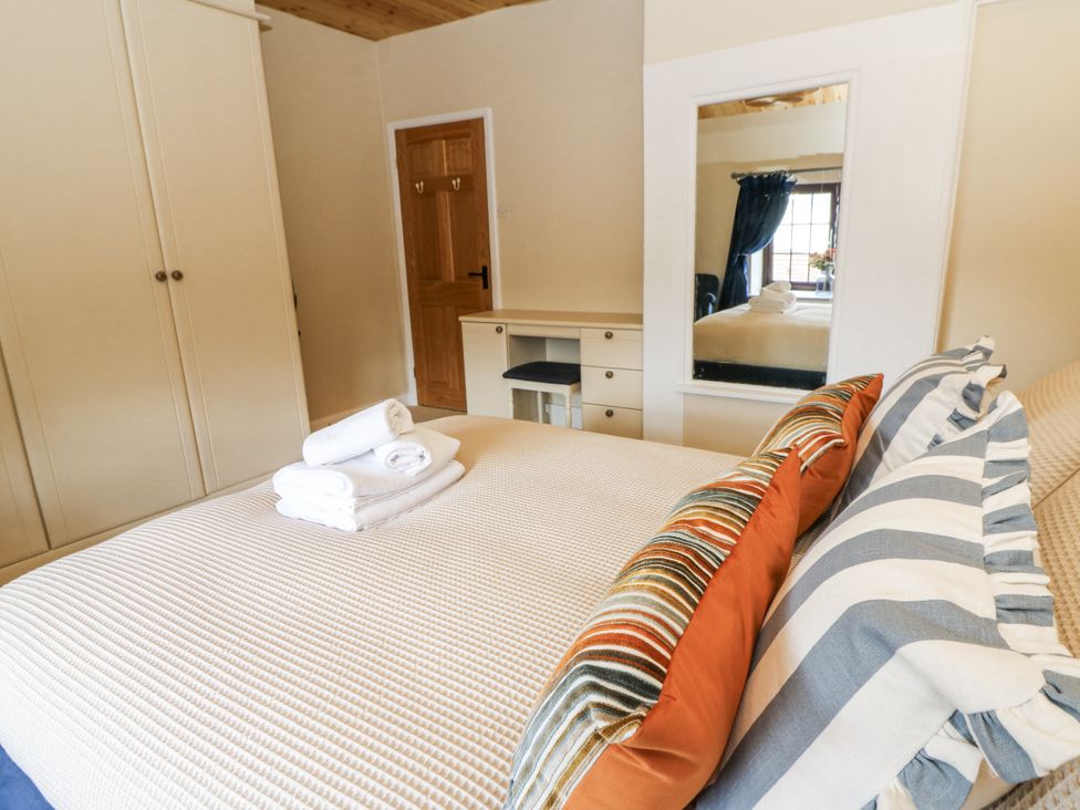 A bedroom with a bed and wardrobe at Stud Farm House in Bleddfa near Knighton