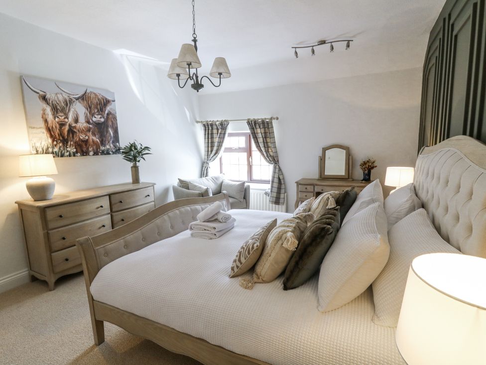 A bedroom with a bed, chest of drawers, and lamp at Stud Farm House in Bleddfa near Knighton
