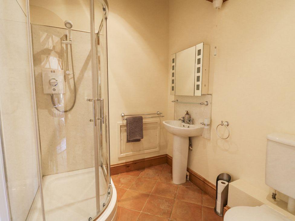 A bathroom with a shower, sink, and toilet at Stud Farm House in Bleddfa near Knighton