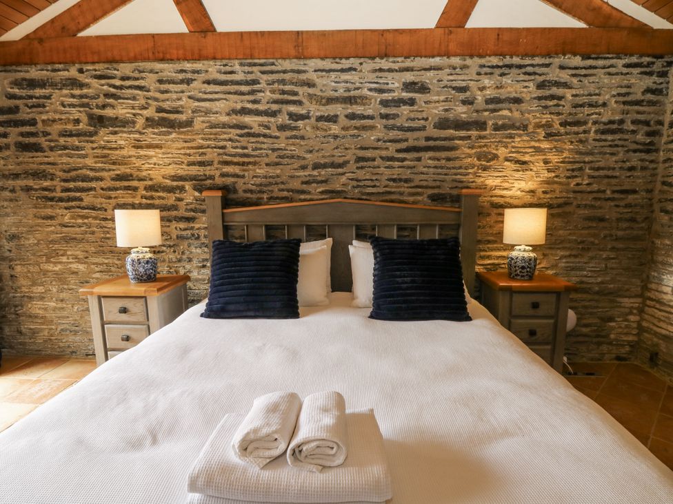 A bedroom with a large bed and bedside tables at Stud Farm House Bleddfa near Knighton