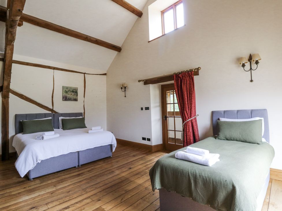 A bedroom with two beds and a window at Stud Farm House in Bleddfa near Knighton