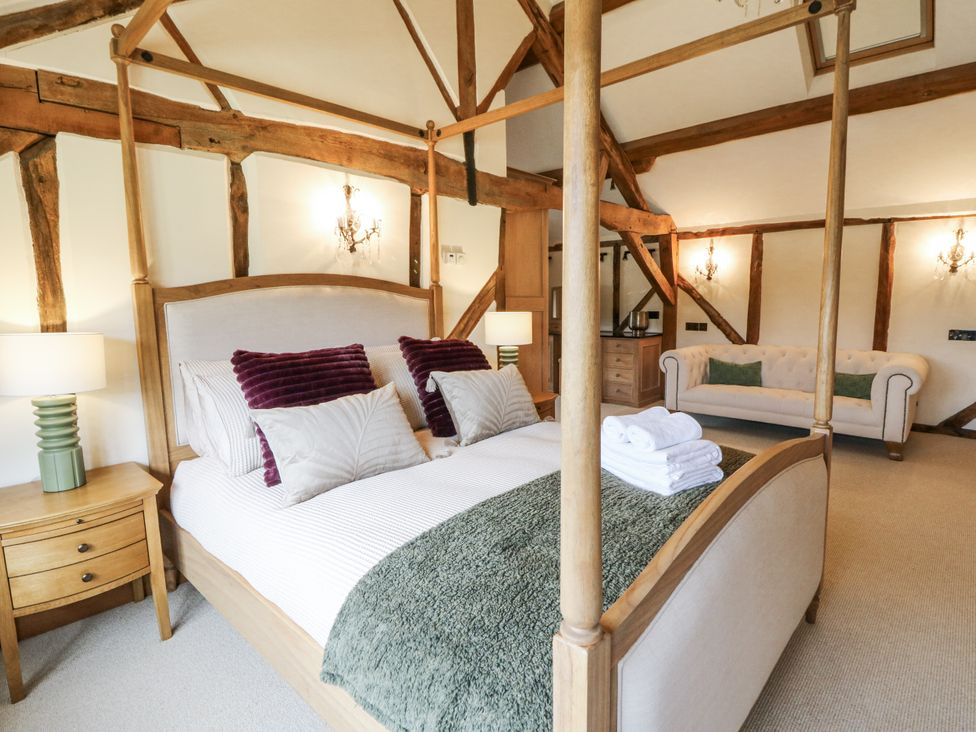 A bedroom with a four-poster bed and seating area at Stud Farm House Bleddfa near Knighton