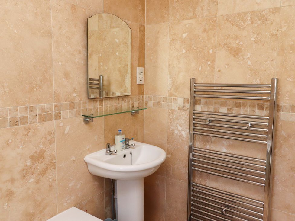 A bathroom with a sink and towel rail at Godetia Cottage in Seahouses