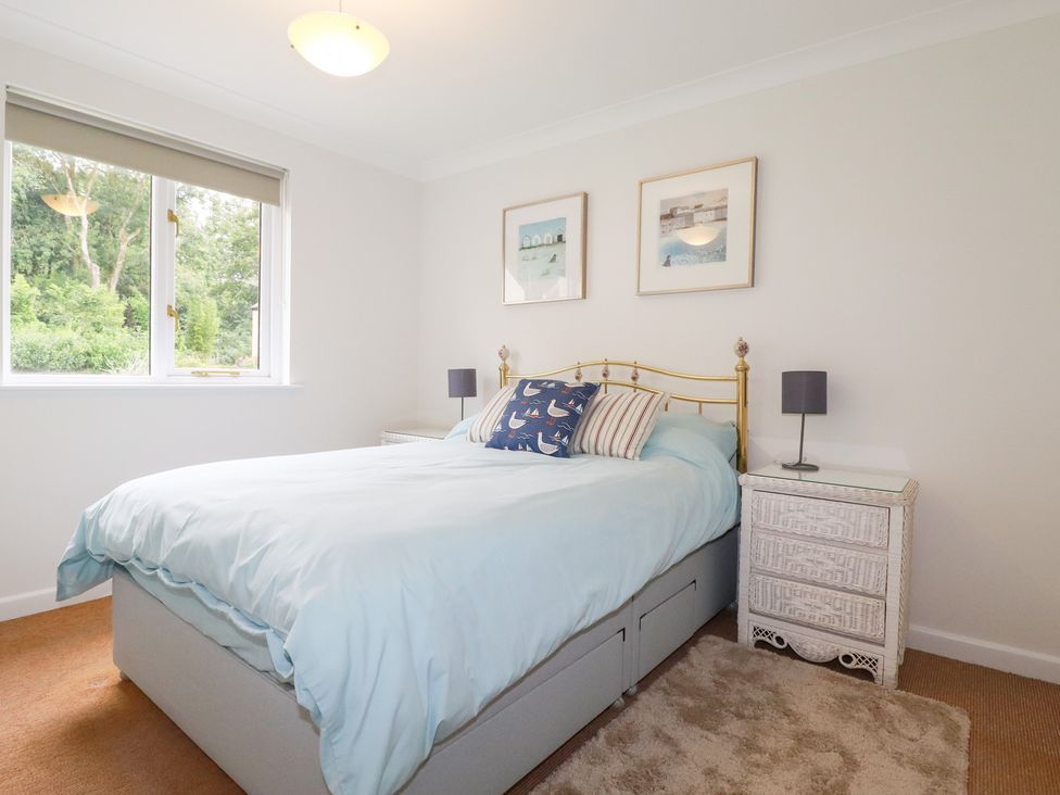 A bedroom with a bed and nightstand at Acorns in Falmouth