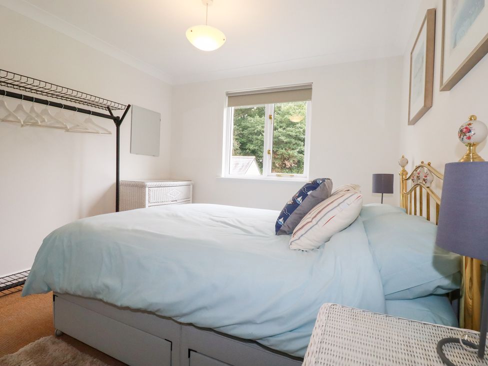 A bedroom with a bed and clothing storage at Acorns in Falmouth