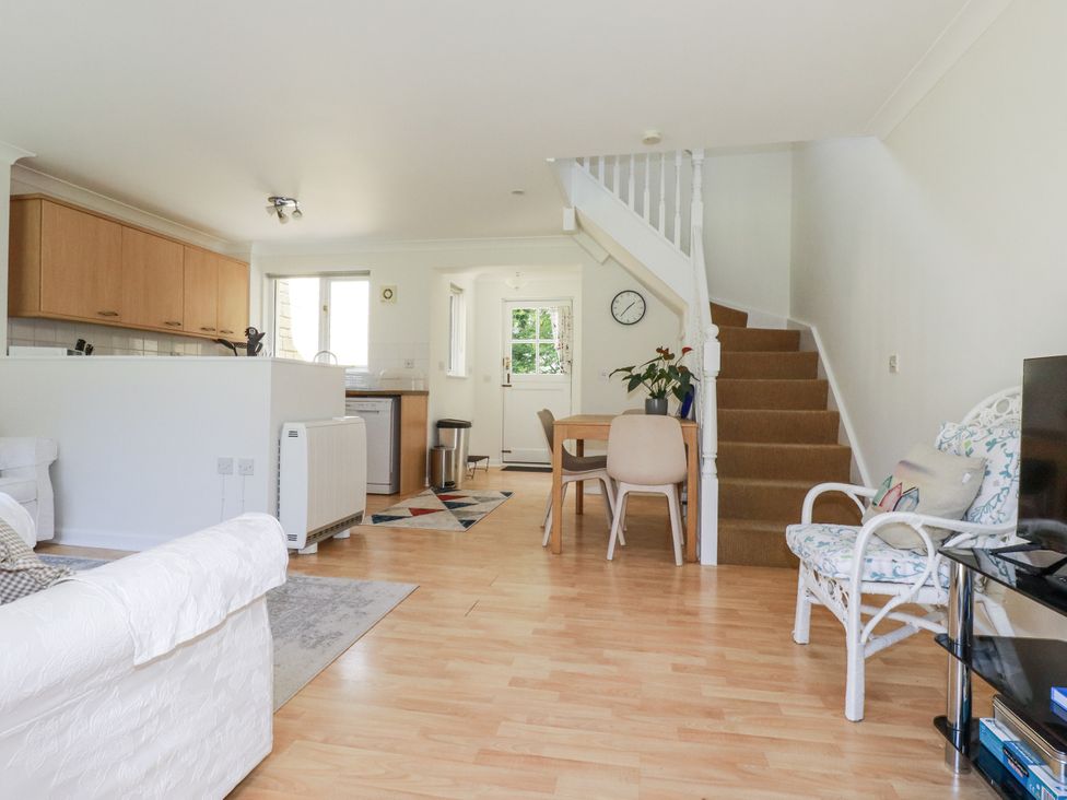 A living room with a sofa and dining area at Acorns in Falmouth