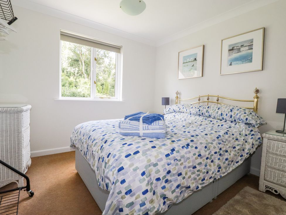 A bedroom with a bed and dresser at Acorns in Falmouth