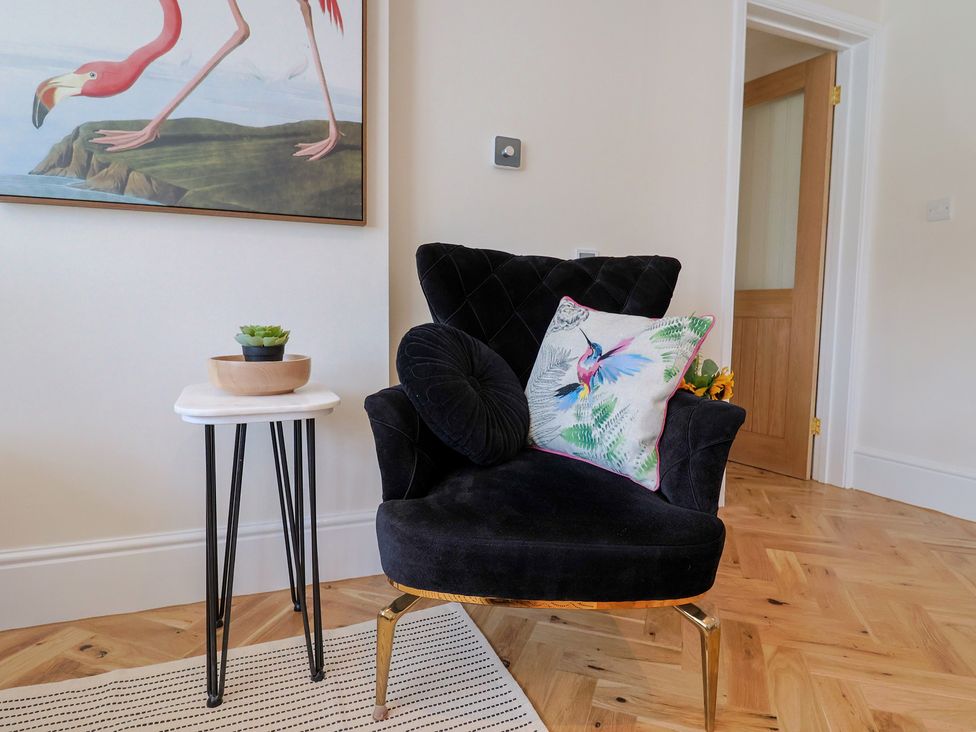 A chair with a cushion and small table in a living room at 1 Mill Green Court Lyme Regis