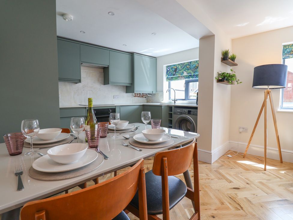 A kitchen with a dining table set for dinner at 1 Mill Green Court in Lyme Regis