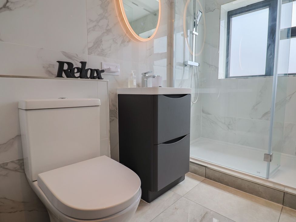 A bathroom with a shower and a vanity cabinet at 1 Mill Green Court in Lyme Regis