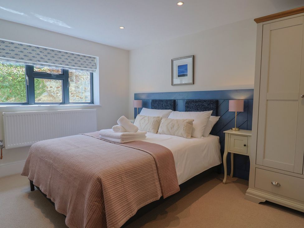 A bedroom with a bed and wardrobe at 1 Mill Green Court in Lyme Regis