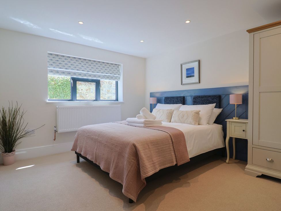 A bedroom with a bed and nightstand at 1 Mill Green Court Lyme Regis