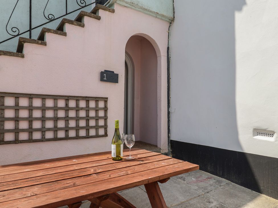 An outdoor area with a table and wine bottle at 1 Mill Green Court Lyme Regis
