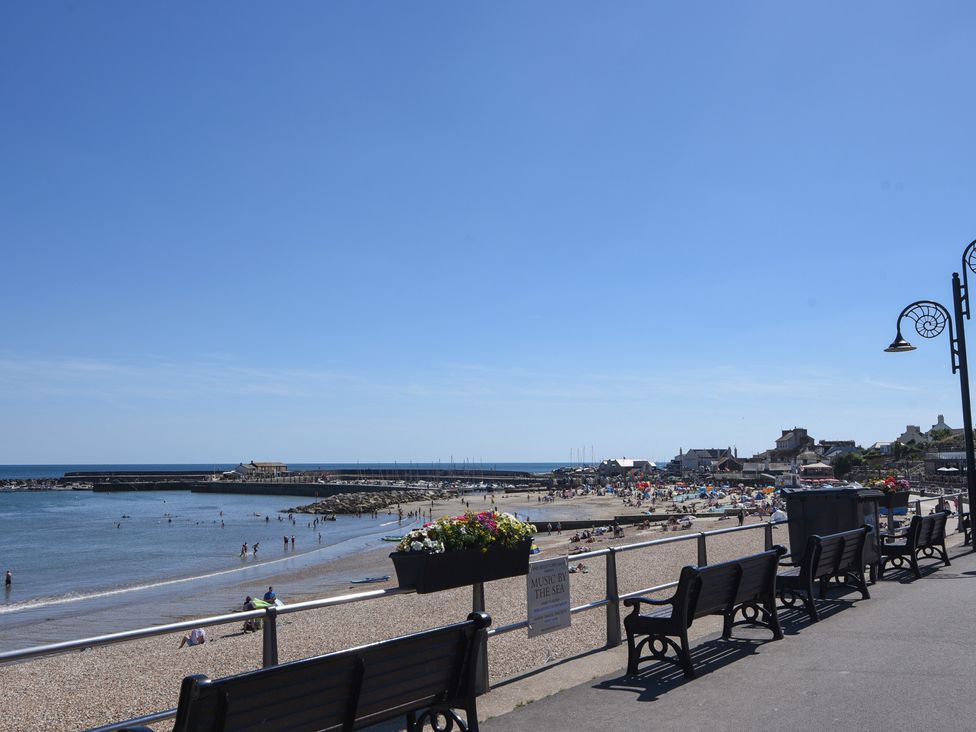 A beach view with benches and people at 1 Mill Green Court Lyme Regis