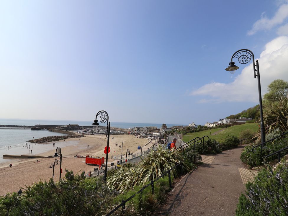 A view of a beach with a pathway and lamp posts at 1 Mill Green Court Lyme Regis