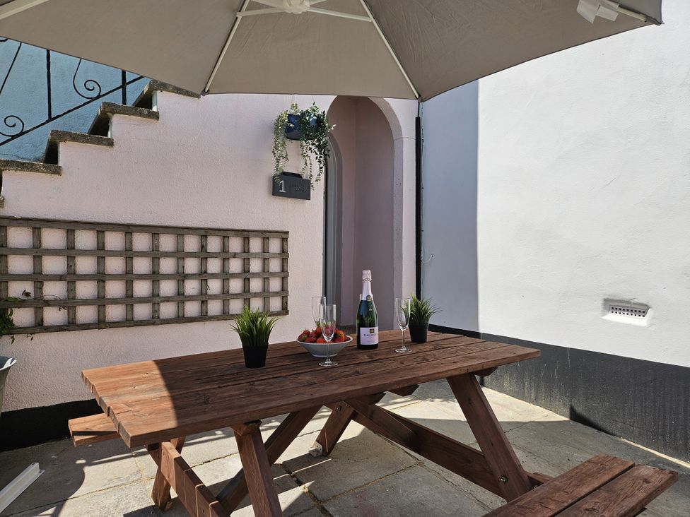 An outdoor seating area with a table and champagne at 1 Mill Green Court in Lyme Regis