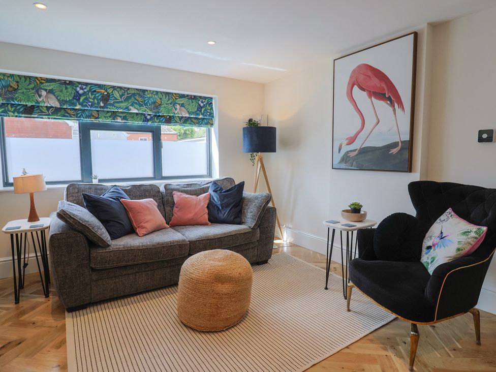 A living room with a sofa and lamp at 1 Mill Green Court Lyme Regis