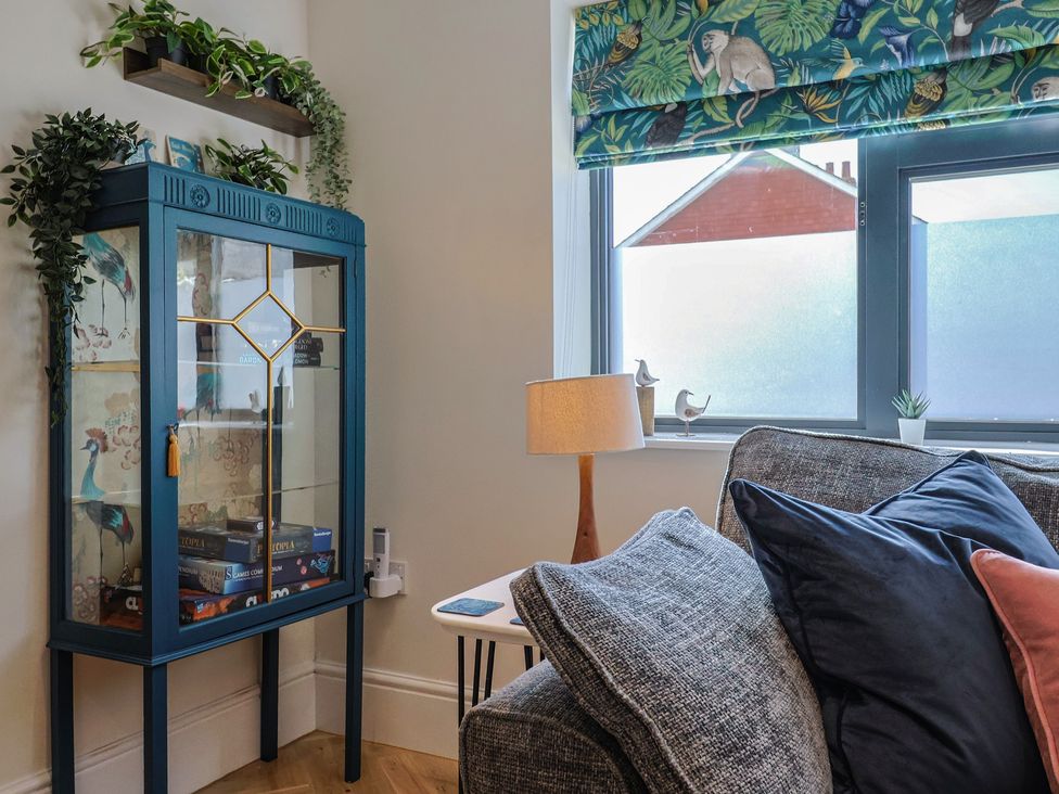 A living room with a display cabinet and a sofa at 1 Mill Green Court in Lyme Regis