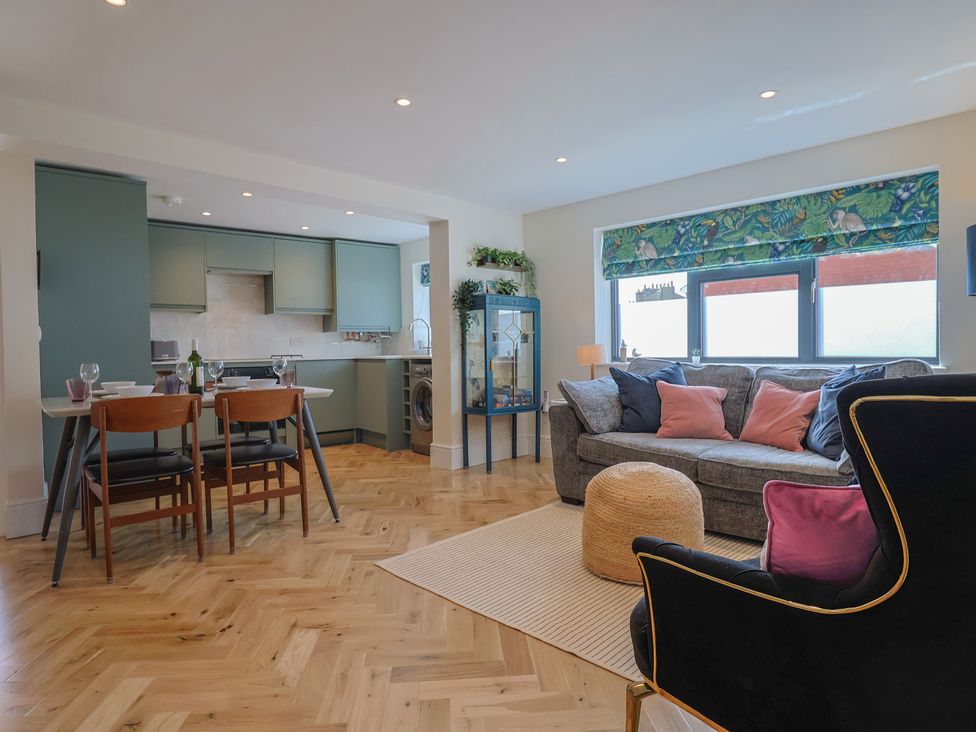A living room with a dining area and kitchen at 1 Mill Green Court in Lyme Regis