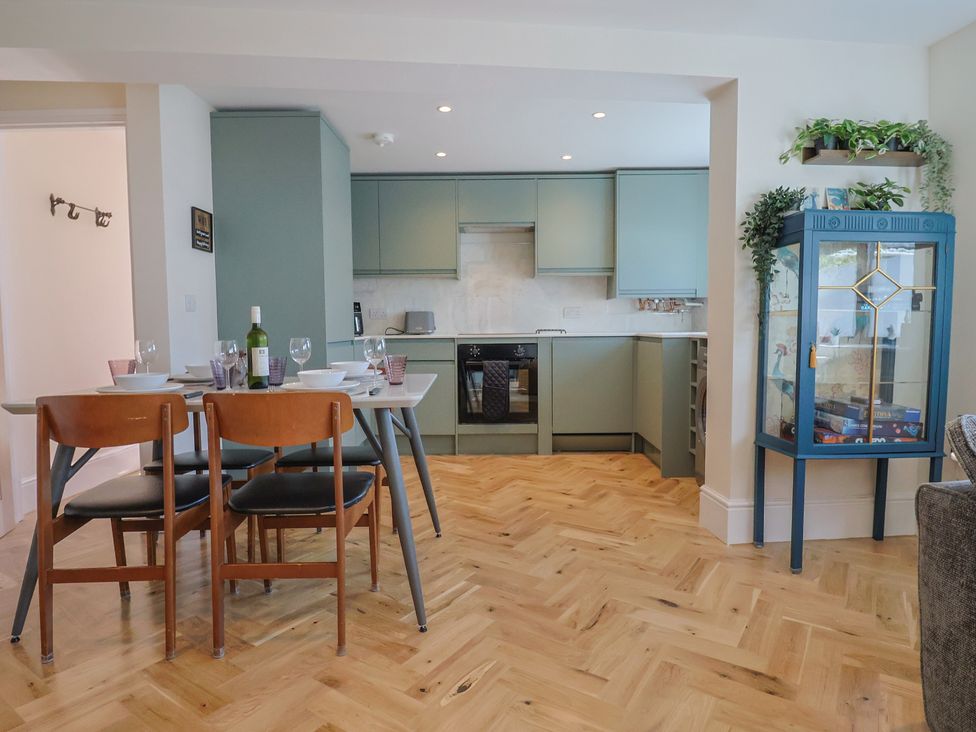 A kitchen with dining table and display cabinet at 1 Mill Green Court in Lyme Regis
